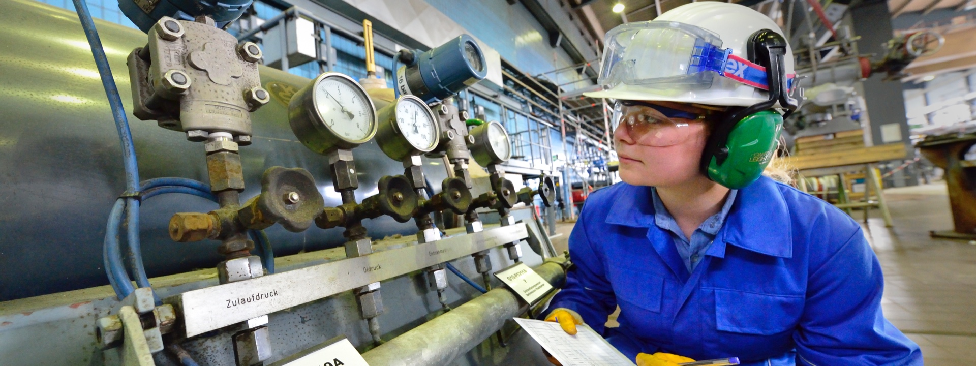 Person in a factory looking at pressure meters