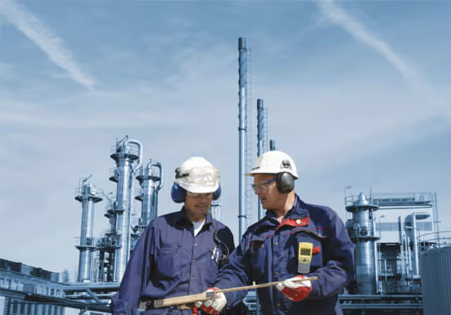 Two men workers having a discussing in front of a factory
