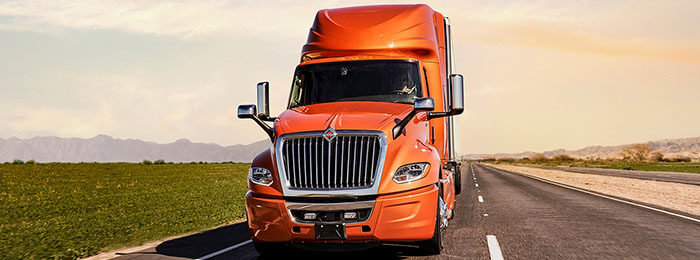 Orange commercial truck on a road